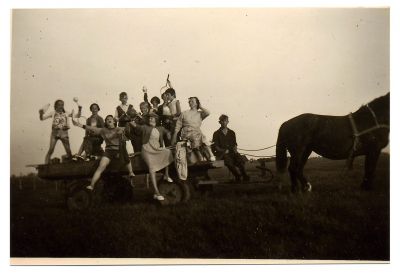 Groepje vrouwen op boerenwagen met paard